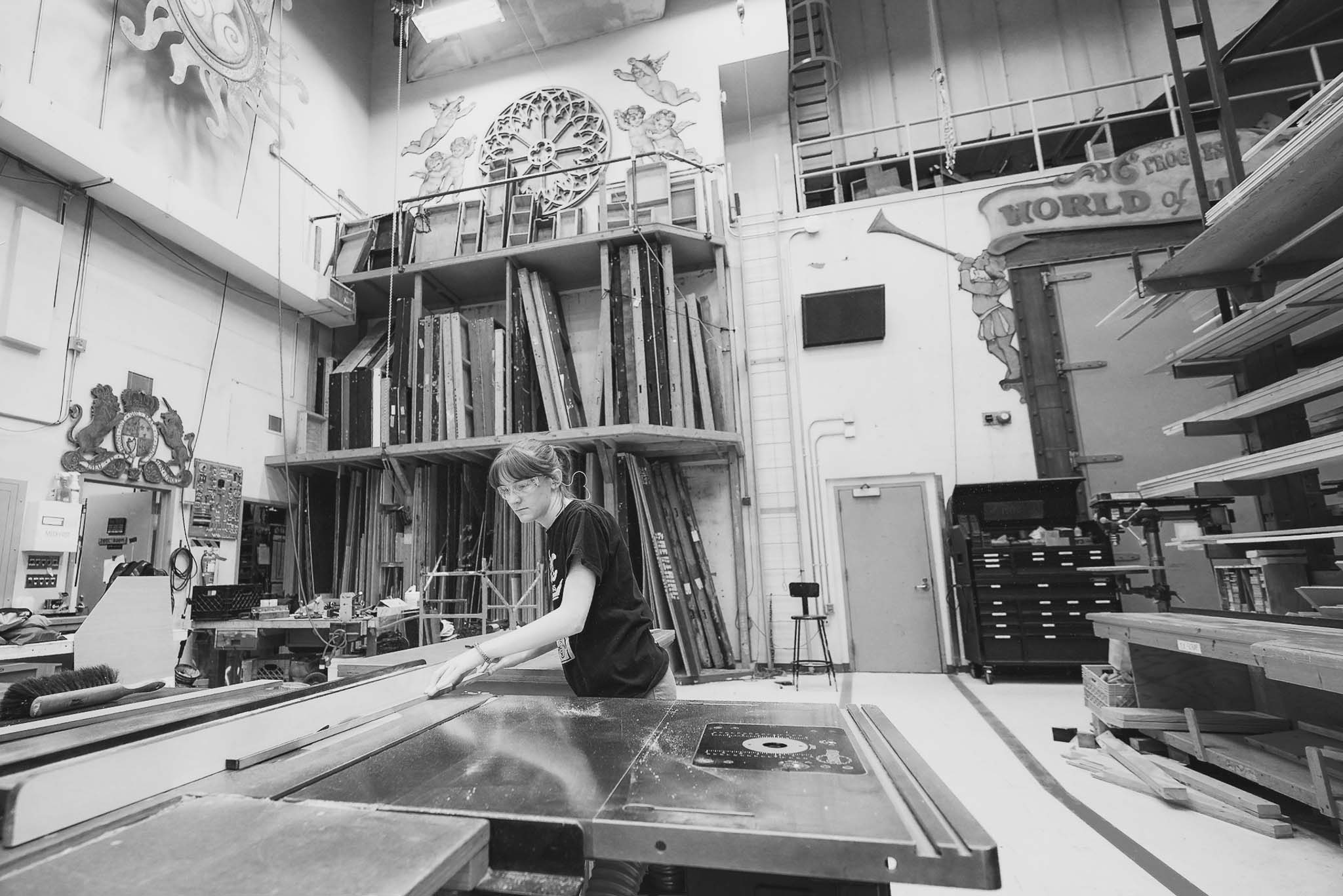 A student works on a table saw in the scenery shop.
