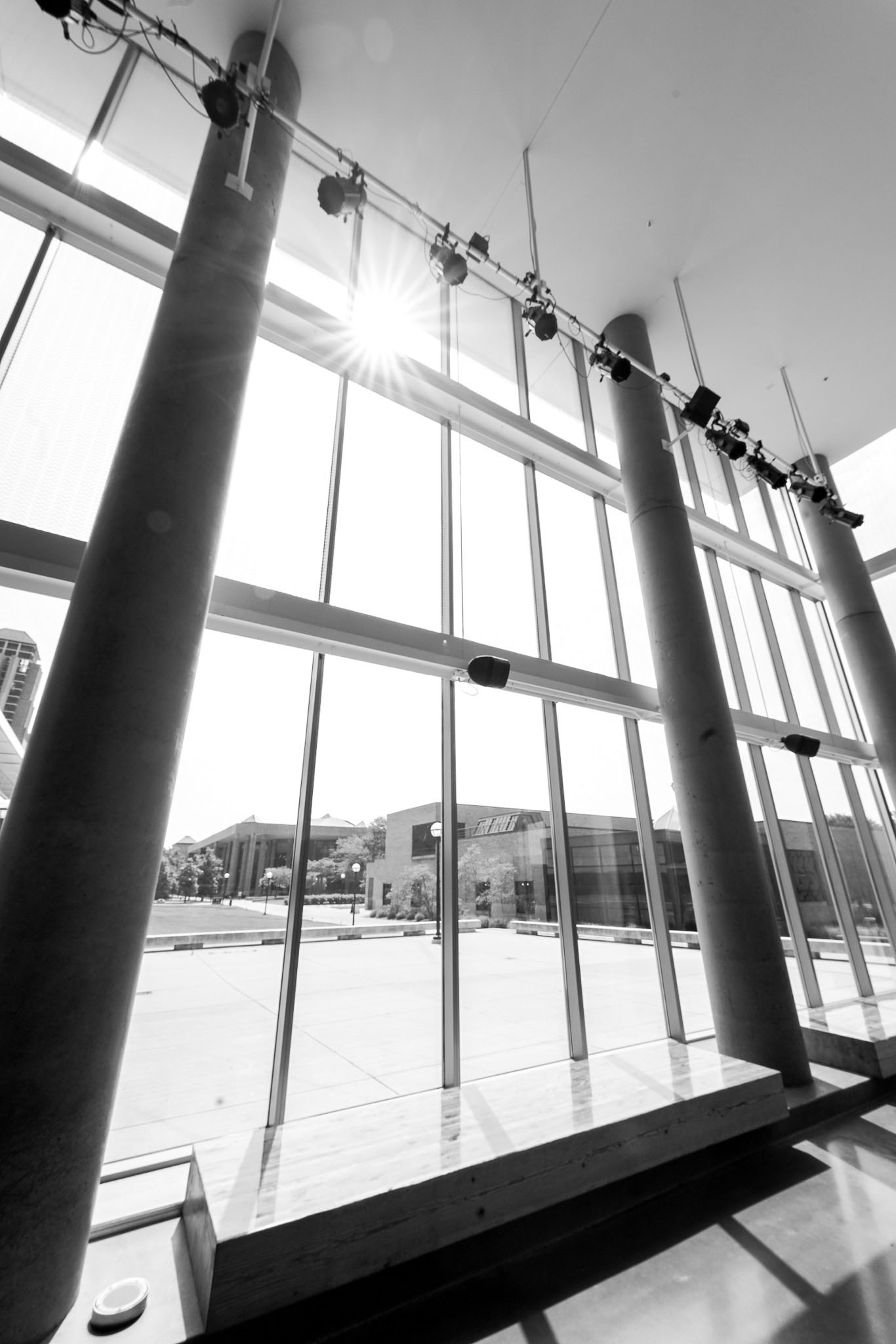 A bench and a glass wall looking outdoors from the Walgreen Drama Center lobby.