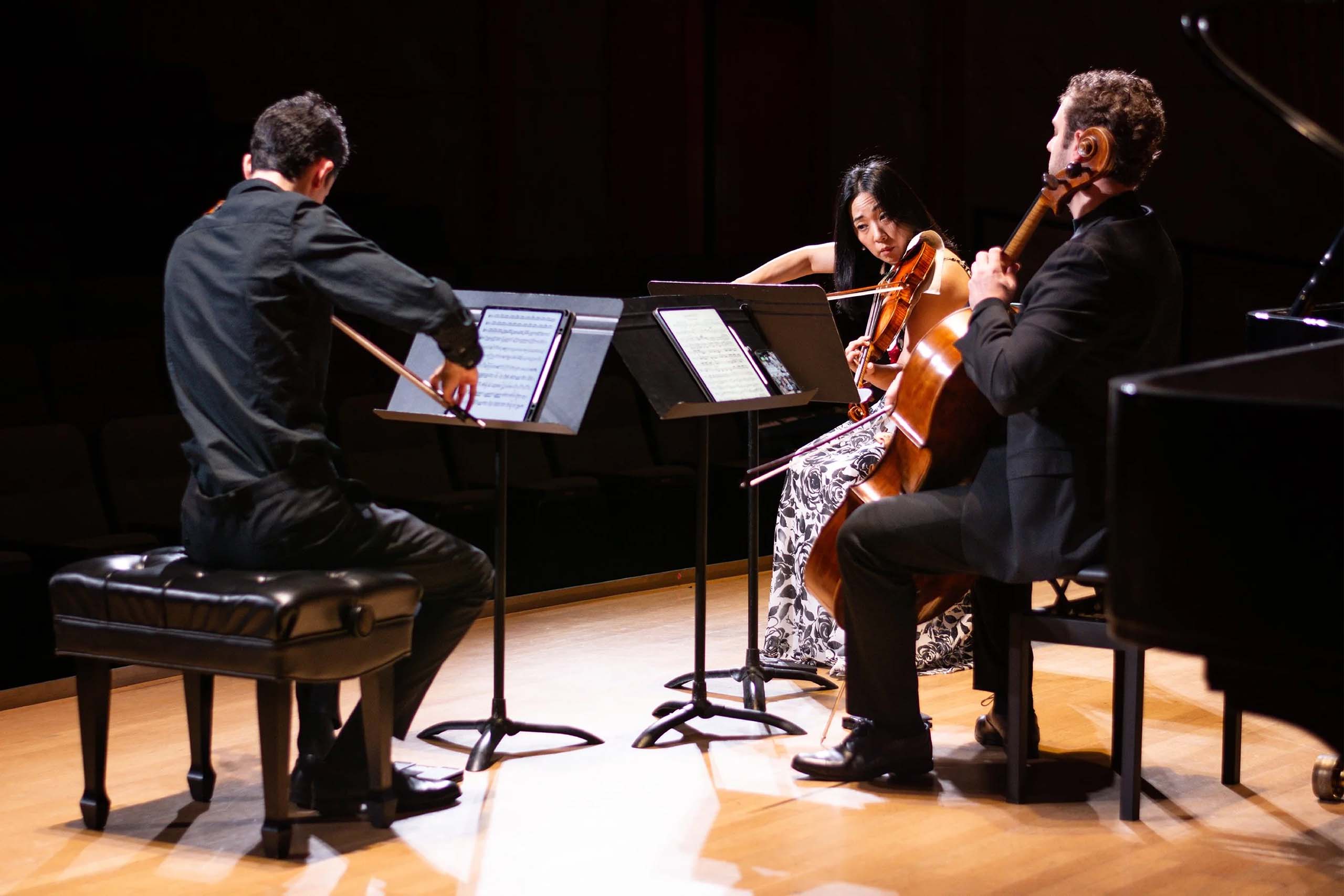 A string trio performs on stage.