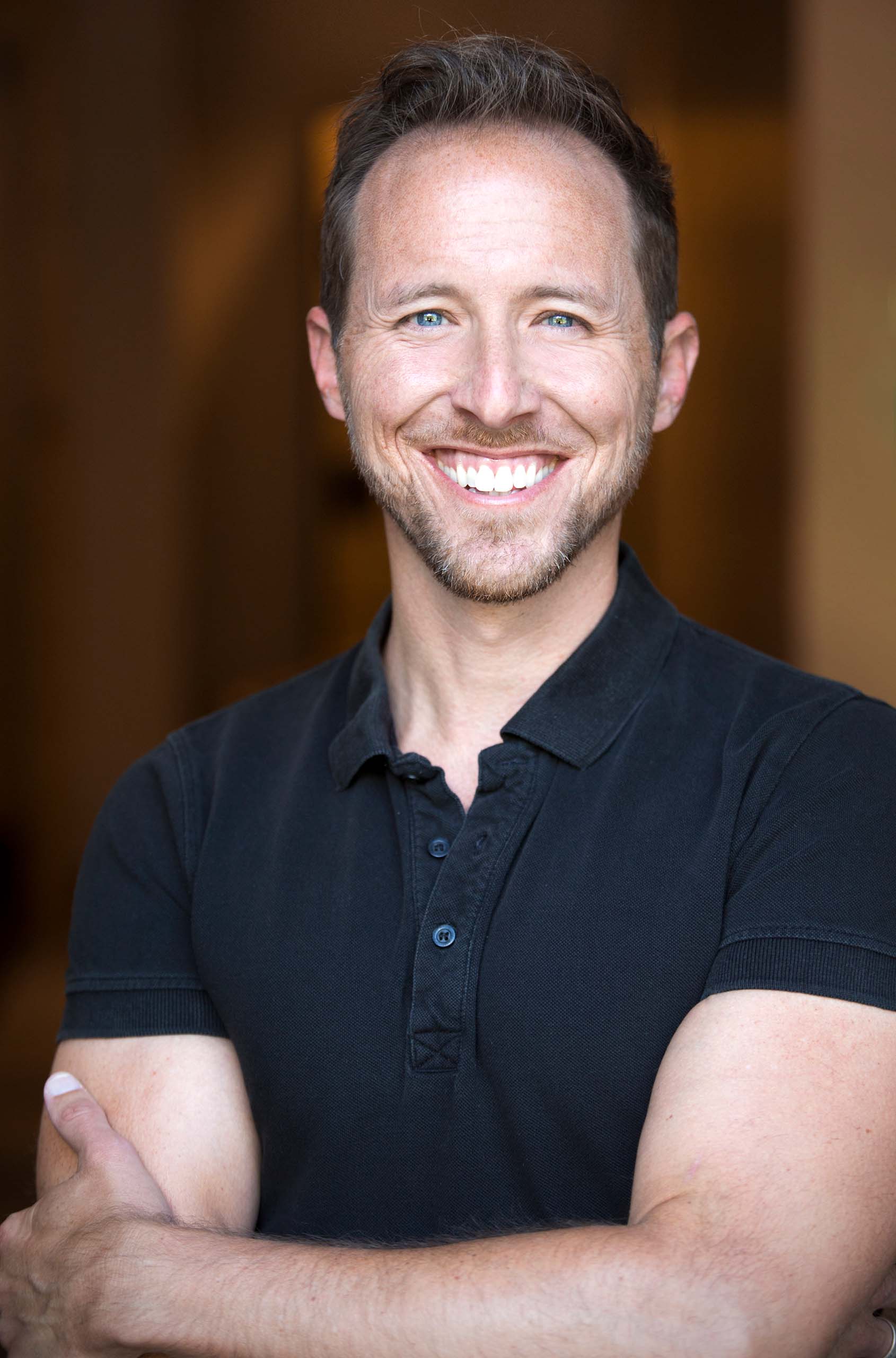 Portrait of Mark Craig with arms folded in a casual black shirt.