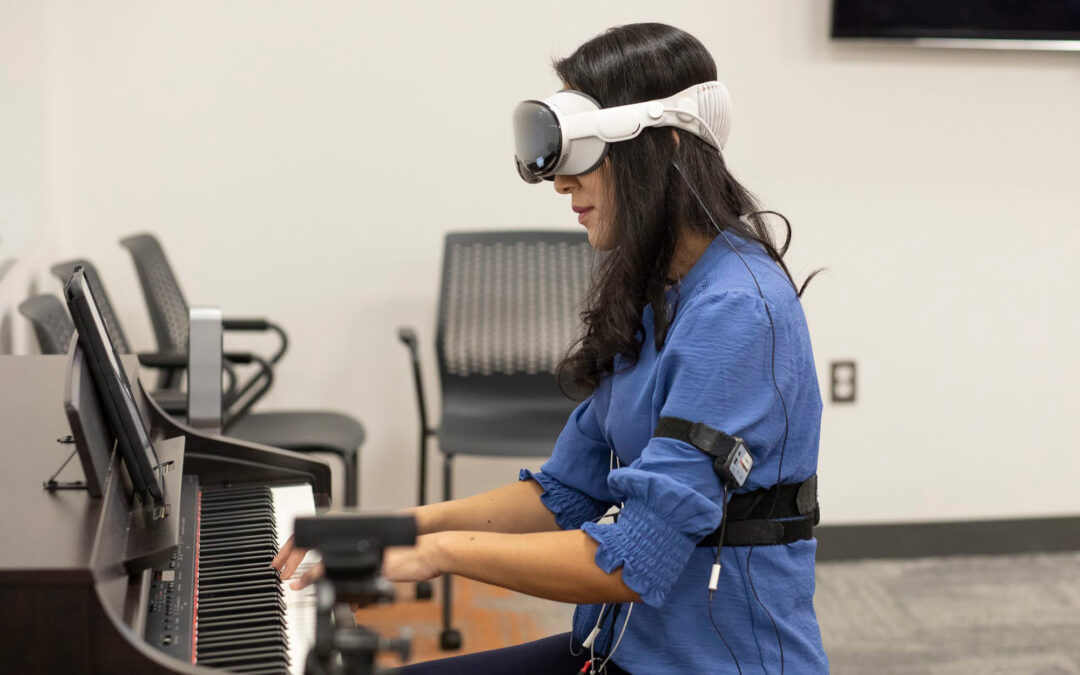 A person plays piano while wearing an extended reality headset and gear.